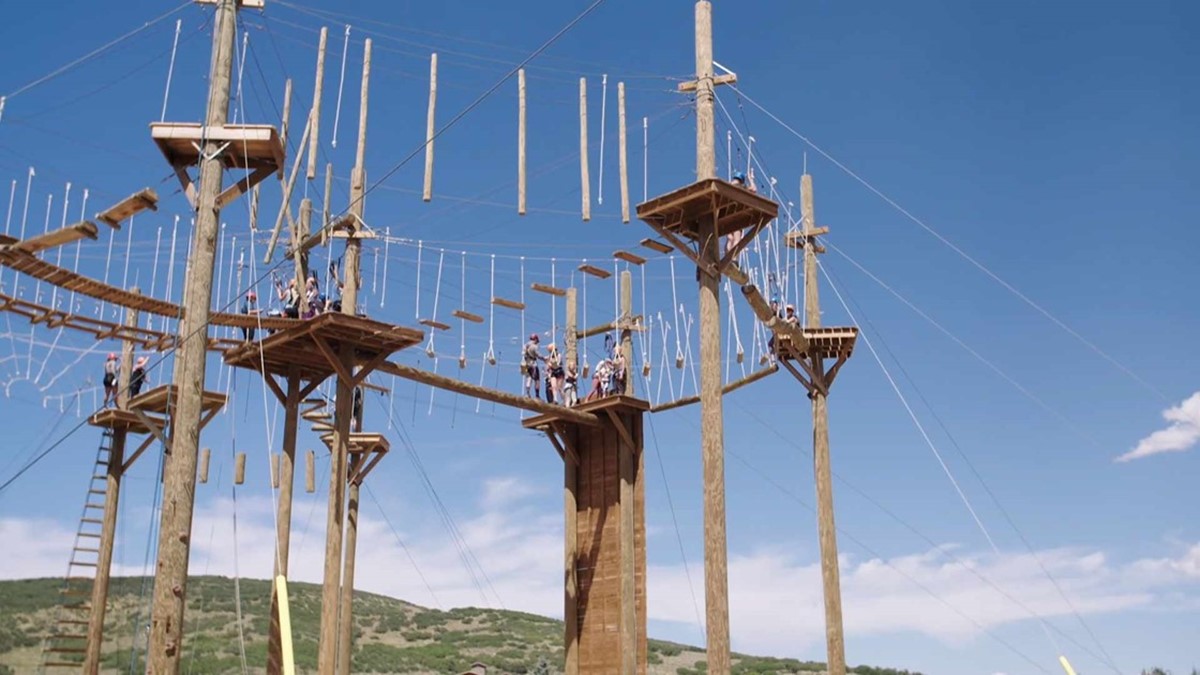 Large climbing structure made of wood and ropes.