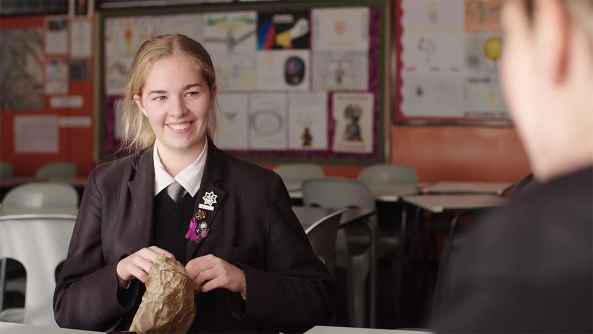 Zoe smiling, wearing her school uniform.