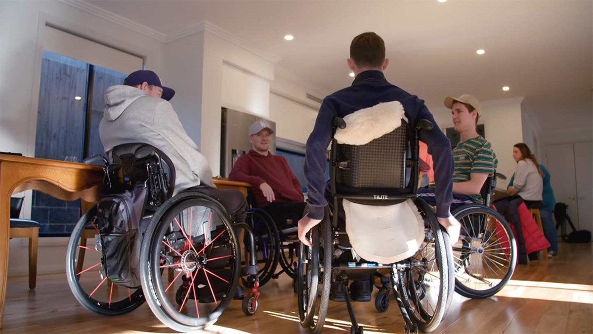 A group of men in wheelchairs talking to eachother.
