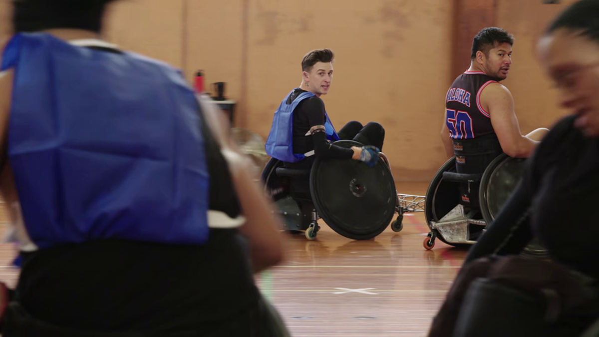 Cody holding the ball, playing wheelchair rugby.