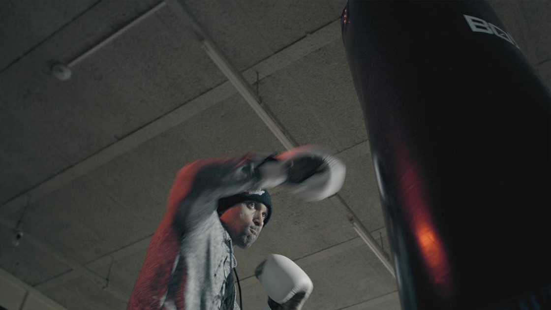 Paul punching a boxing bag.
